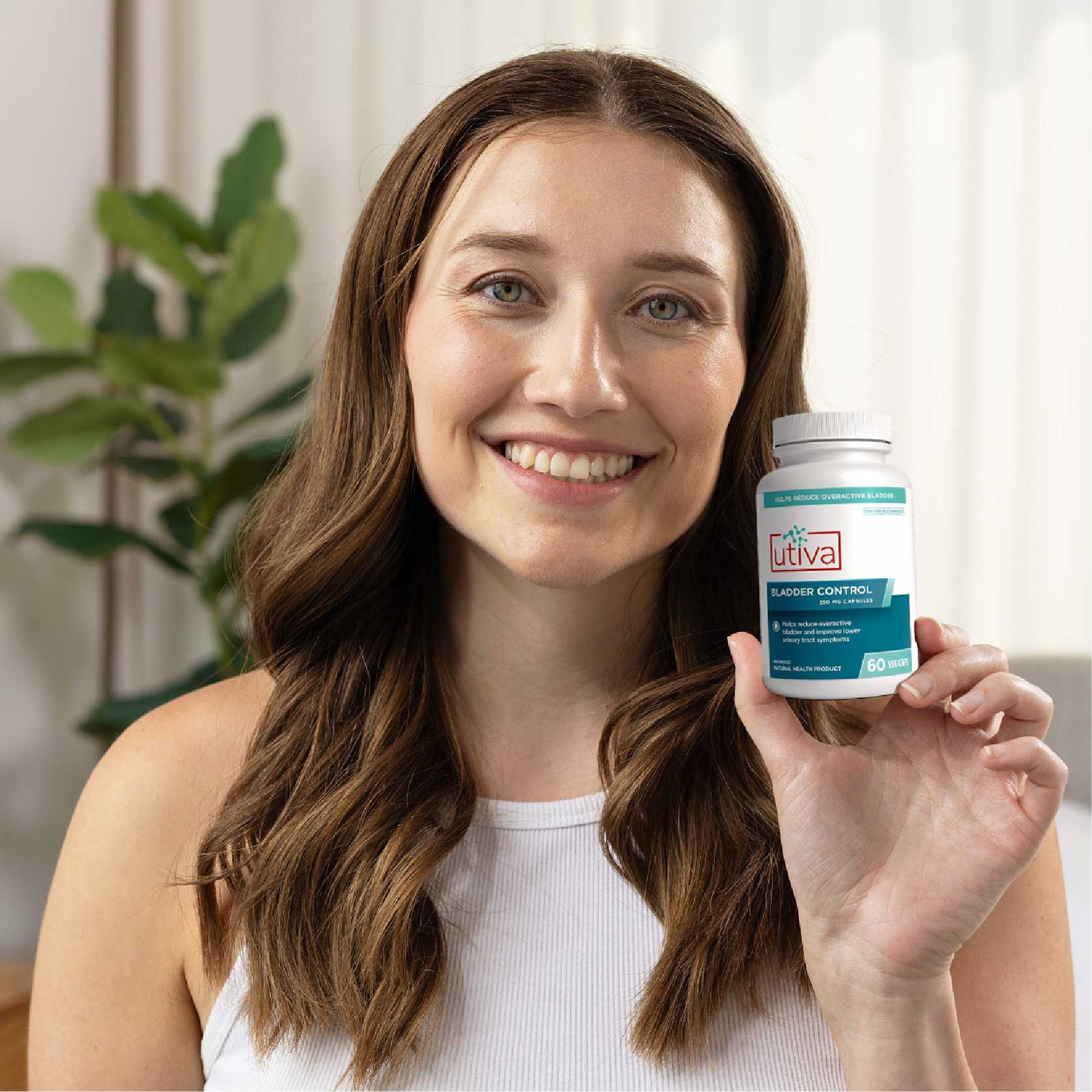 Woman holding a bottle of Lutvia product in a bright indoor setting