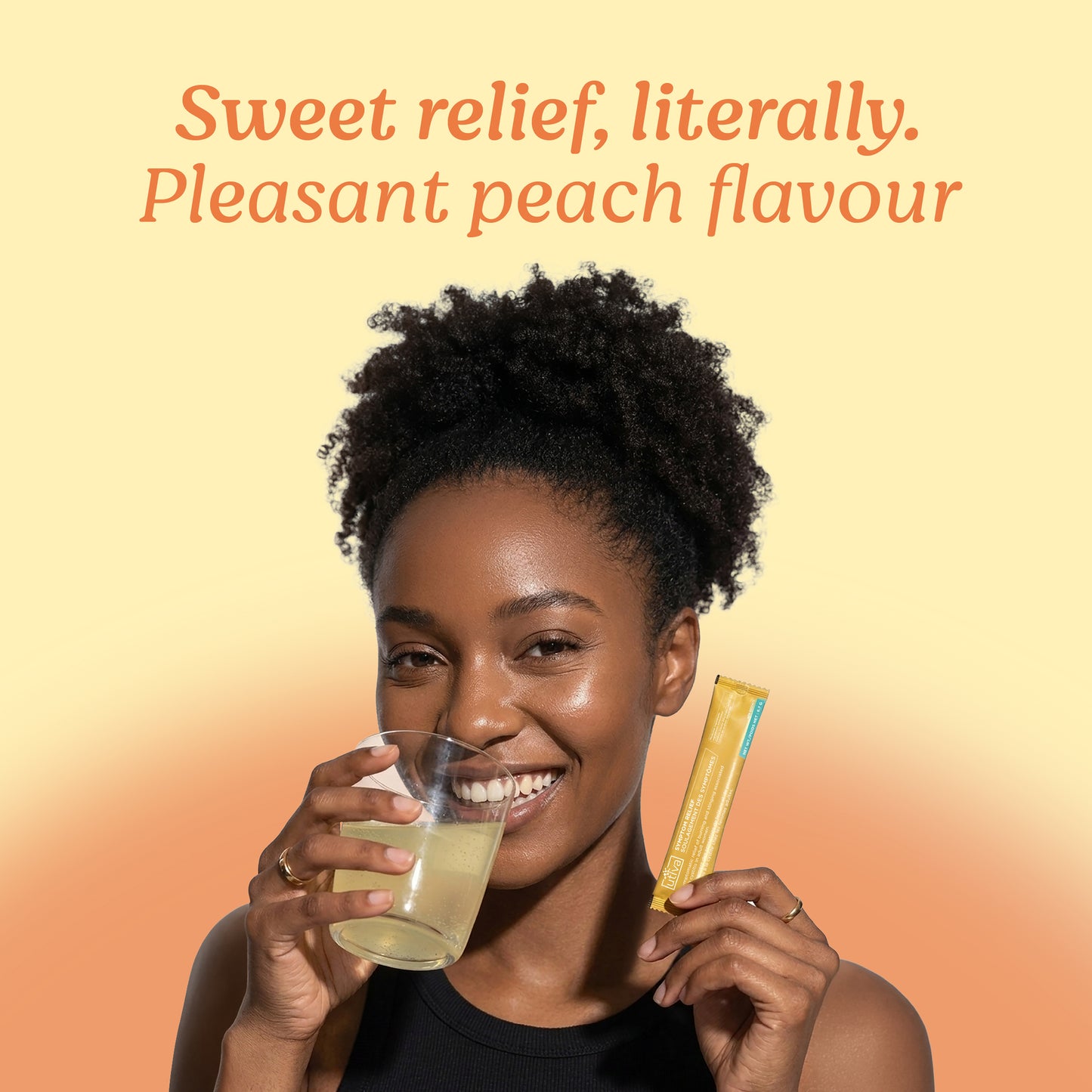 A smiling woman holds a glass of pale yellow liquid and a yellow stick pack against a warm peach-to-yellow gradient background, with the text 'Sweet relief, literally. Pleasant peach flavour' at the top.